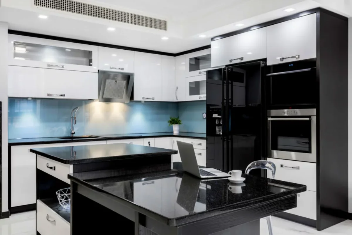 آشپزخانه با کابینت هایگلاس سفید و یونیت مشکی با دستگیره‌های نقره‌ای
