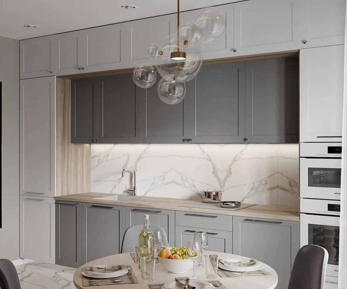 کابینت نئوکلاسیک دو رنگ سفید و طوسی با طرح پله‌ای برای آشپزخانه مدرن