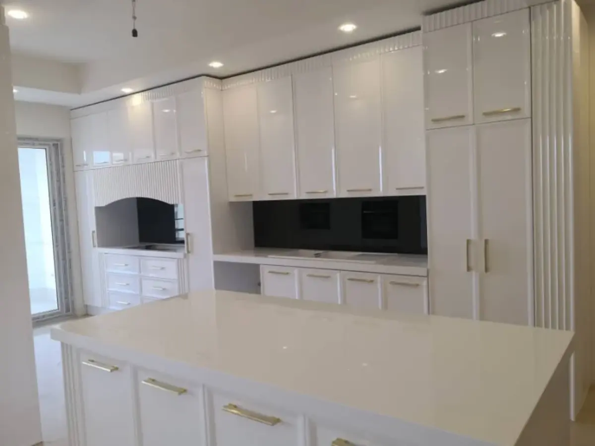 آشپزخانه با کابینت پولیشی دارای دستگیره خطی طلایی