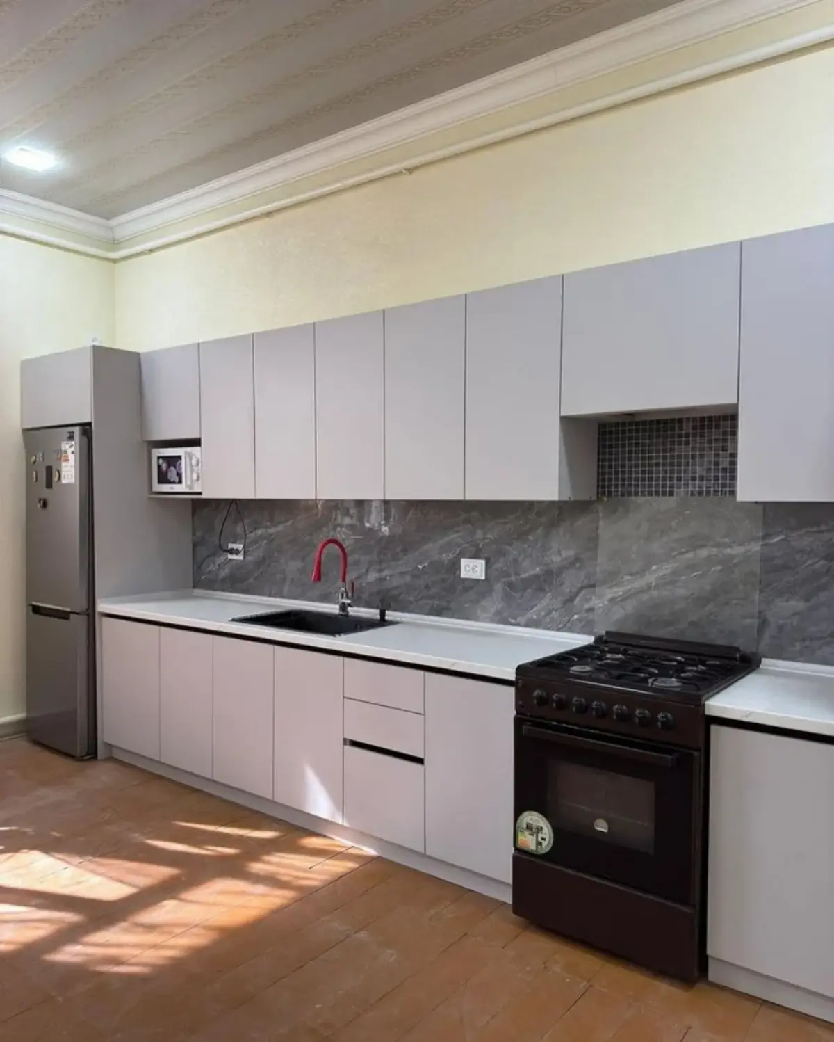کابینت فلزی با درب ام دی اف به رنگ سفید با مابین کابینتی سنگی به رنگ مشکی