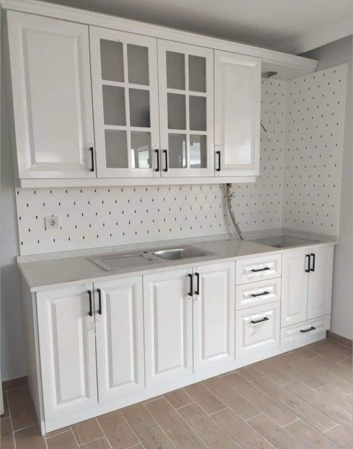 کابینت نئوکلاسیک ممبران سفید صدفی با درب‌های شیشه‌ای و دستگیره‌های مشکی