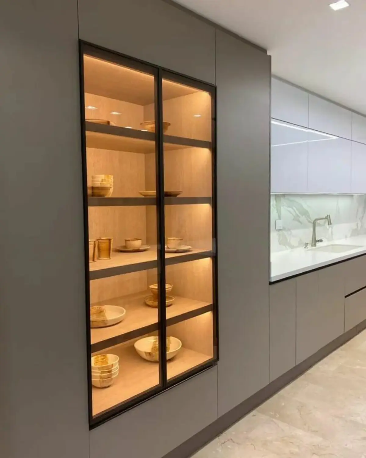 ویترین مرکزی مدرن مشکی با نورپردزای زرد و کابینت مدرن طوسی بدون دستگیره