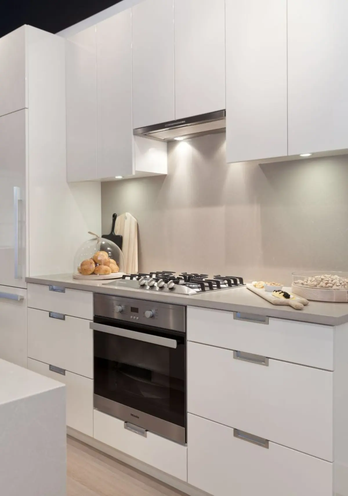 کابینت هایگلاس سفید مات مدرن با دستگیره مخفی فلزی و نورپردازی زیرکابینتی